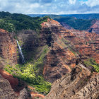 Majestic waterfall in rocky canyon with lush greenery