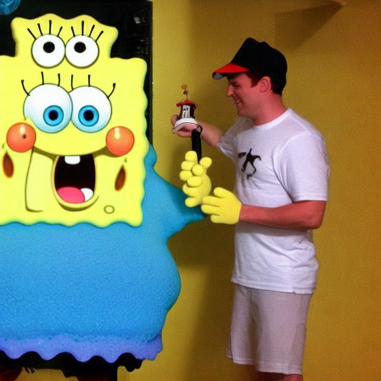 Person in white t-shirt and cap with SpongeBob SquarePants figure and toy