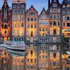 Colorful European-style buildings and boats reflected in calm water