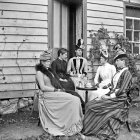 Grayscale illustration of elegantly dressed women at a lavish gathering.