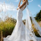 Elegant bride in white gown with floral details and veil.