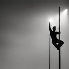 Silhouette of person climbing ladder under sun halo