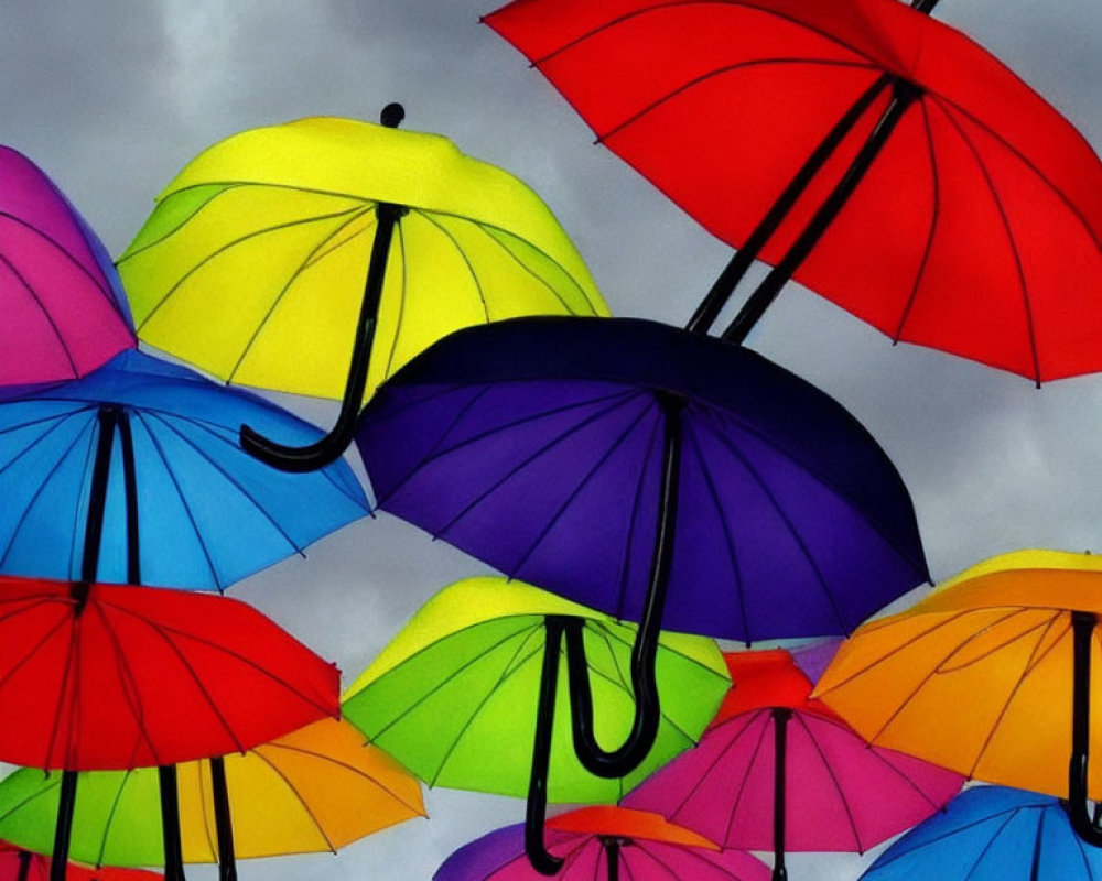 Vibrant multicolored umbrellas under cloudy sky