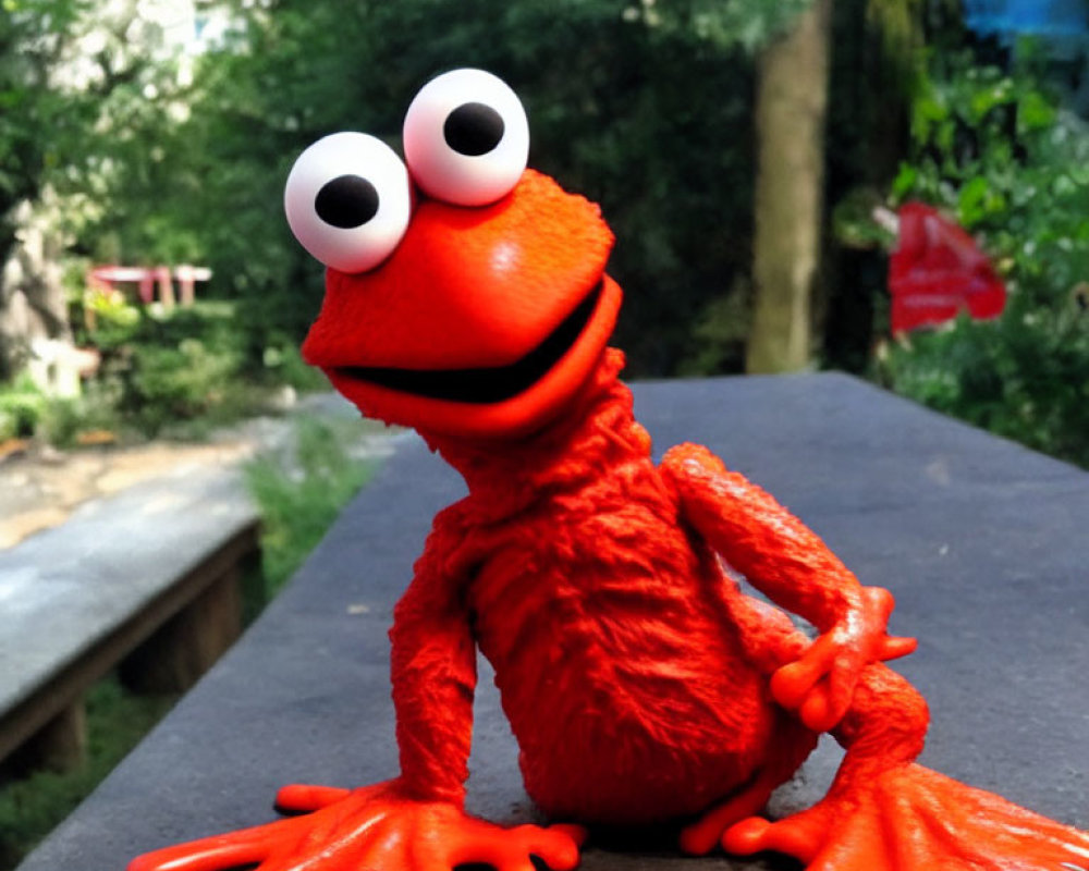 Vivid red puppet with white eyes and orange limbs on outdoor table