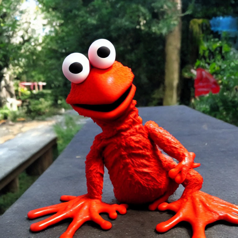 Vivid red puppet with white eyes and orange limbs on outdoor table