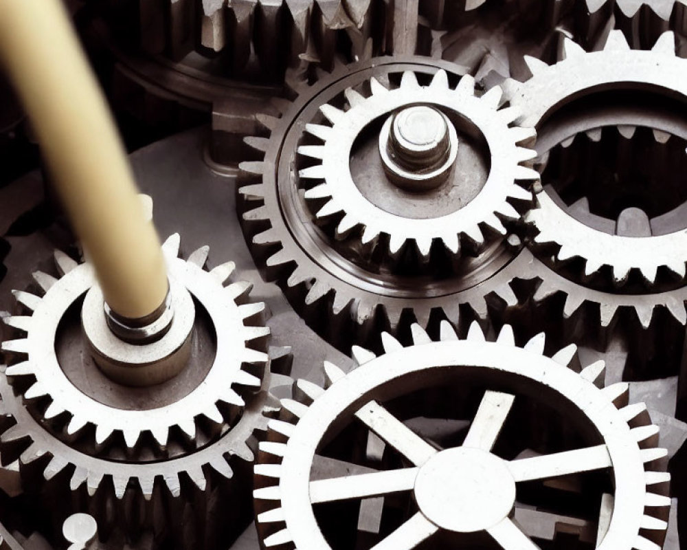 Detailed view of interconnected metallic gears and cogs with varying sizes and intricate teeth design.