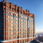 Symmetrical windows on ornate orange building under blue sky