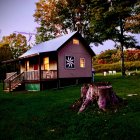 Cozy wooden cabin in lush meadow with mountain backdrop