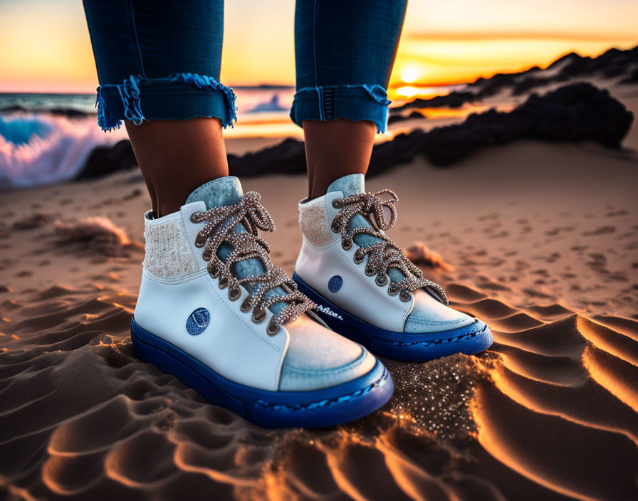 Person wearing white and blue boots on beach at sunset