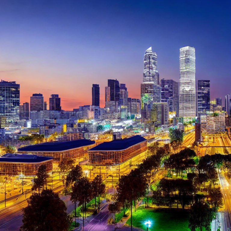 Twilight cityscape with illuminated skyscrapers and park area