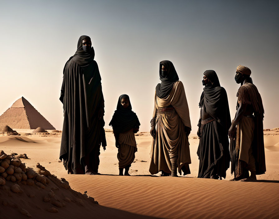 Group of People in Traditional Robes Near Pyramid in Desert