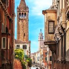 Ancient stone tower and historic buildings on cobblestone street