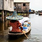 Tranquil harbor with colorful boats, white shack, red-roofed houses, and lily