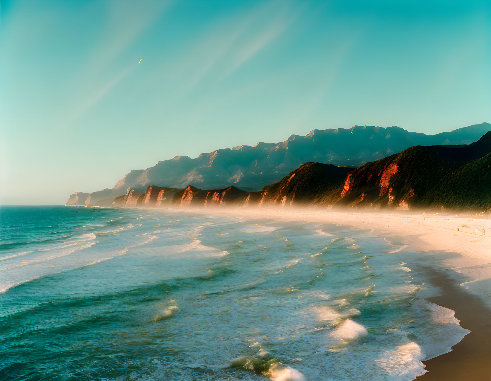 Tranquil sunset beach scene with mountain backdrop