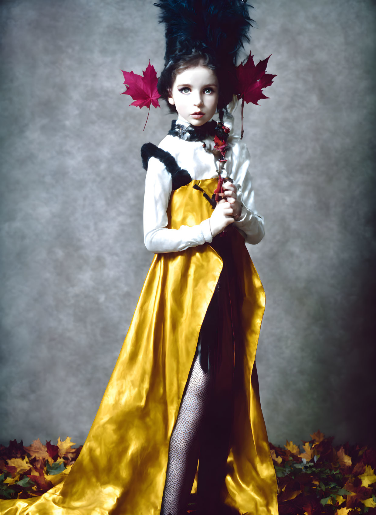 Young girl in yellow dress with autumn leaves backdrop