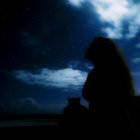 Silhouette of person by lake gazing at rock formation with goat under starry night sky