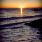 Silhouetted figures in gowns amidst towering waves at sunset