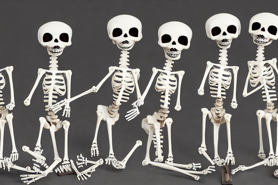 Skeleton Figures with Oversized Skulls in Various Poses Against Dark Background