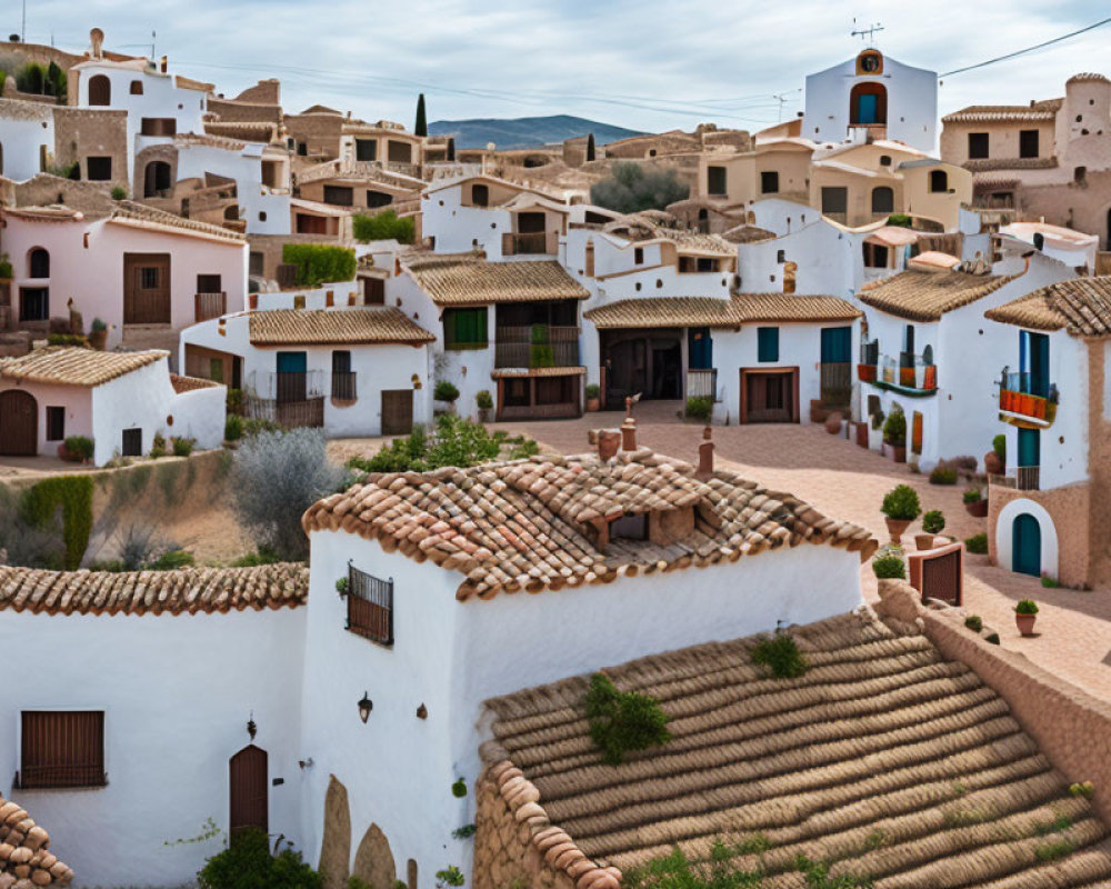 Traditional Mediterranean village with terracotta rooftops and church tower.