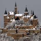 Majestic castle with spires and turrets in snowy landscape at dusk