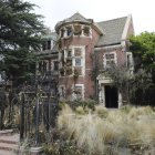 Victorian house surrounded by lush gardens and blooming flowers