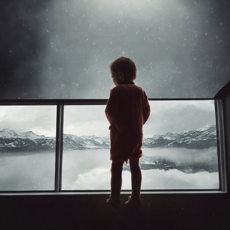 Child in red outfit gazes at snowy mountain through window