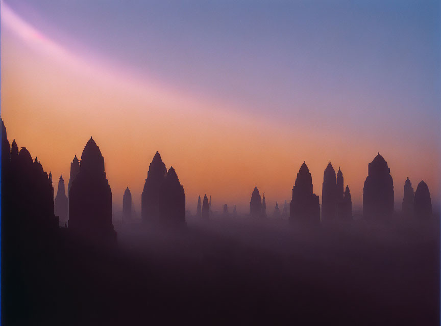 Misty sunrise scene with ancient temple spires