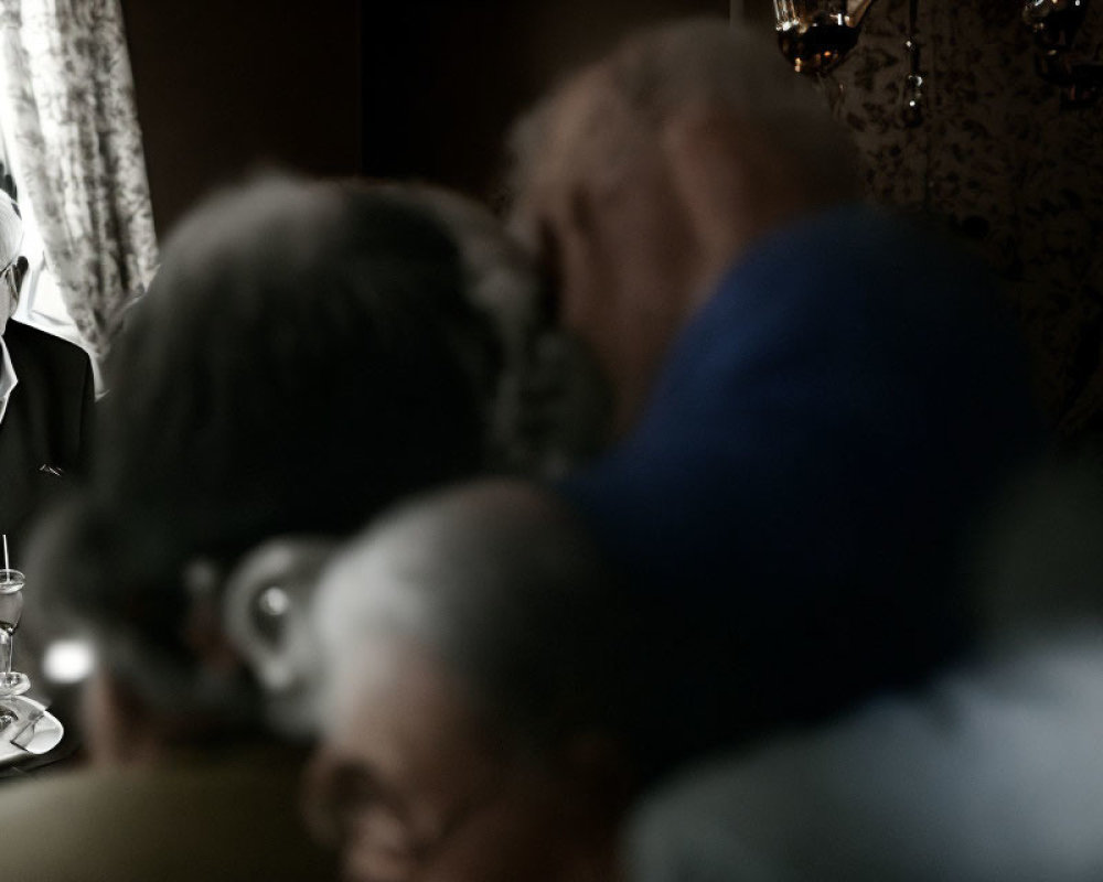 Blurry photo of elderly couple hugging in soft light