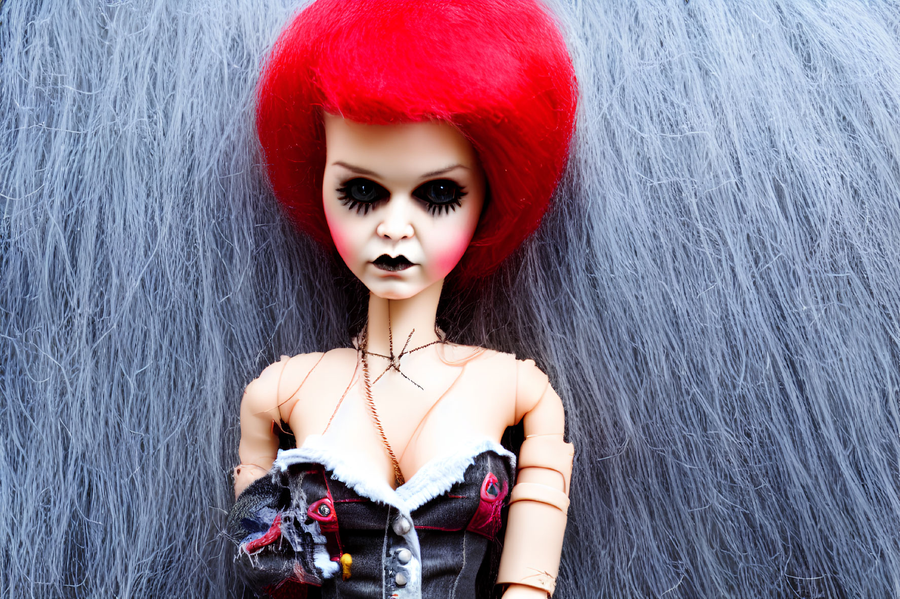 Red Bouffant Hairstyle Doll in Gothic Outfit Against Grey Fur Background