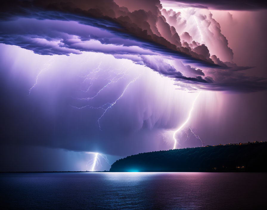 Intense lightning storm over water at night