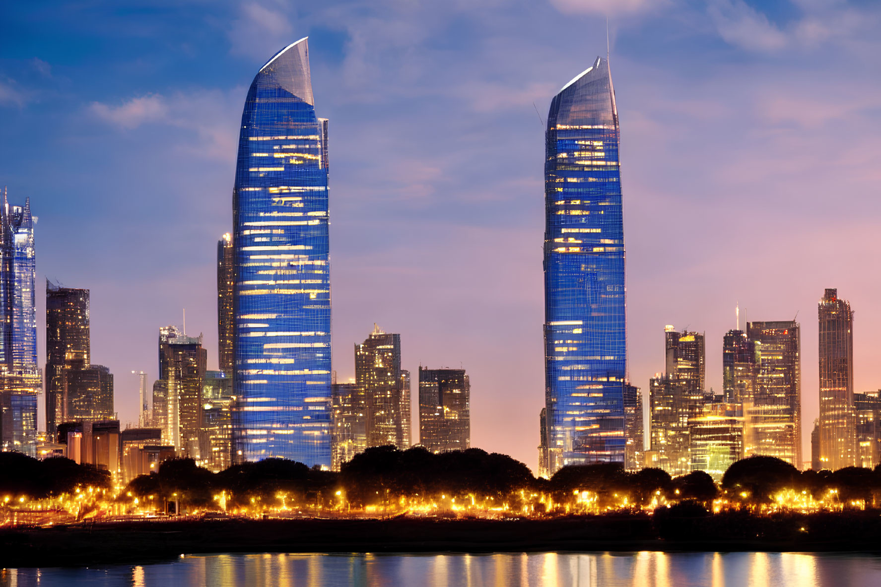 Cityscape with illuminated skyscrapers at dusk and twin glass towers, trees silhouette.