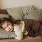 Child Sleeping Peacefully with Owl and Street Lamp in Scene