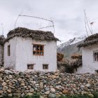 Tranquil rural landscape with white cottages, blooming vines, gardens, and stone wall