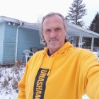 Bearded man in golden shawl against snowy church backdrop