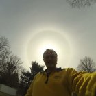 Religious figure with halo blessing, under vivid sky and trees