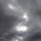 Painting: Three crucified figures under stormy sky, lone observer on rocky terrain