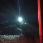 Vintage steam locomotive under full moon with red light - dramatic night scene