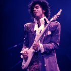 Purple-suited person with ornate guitar on blue background