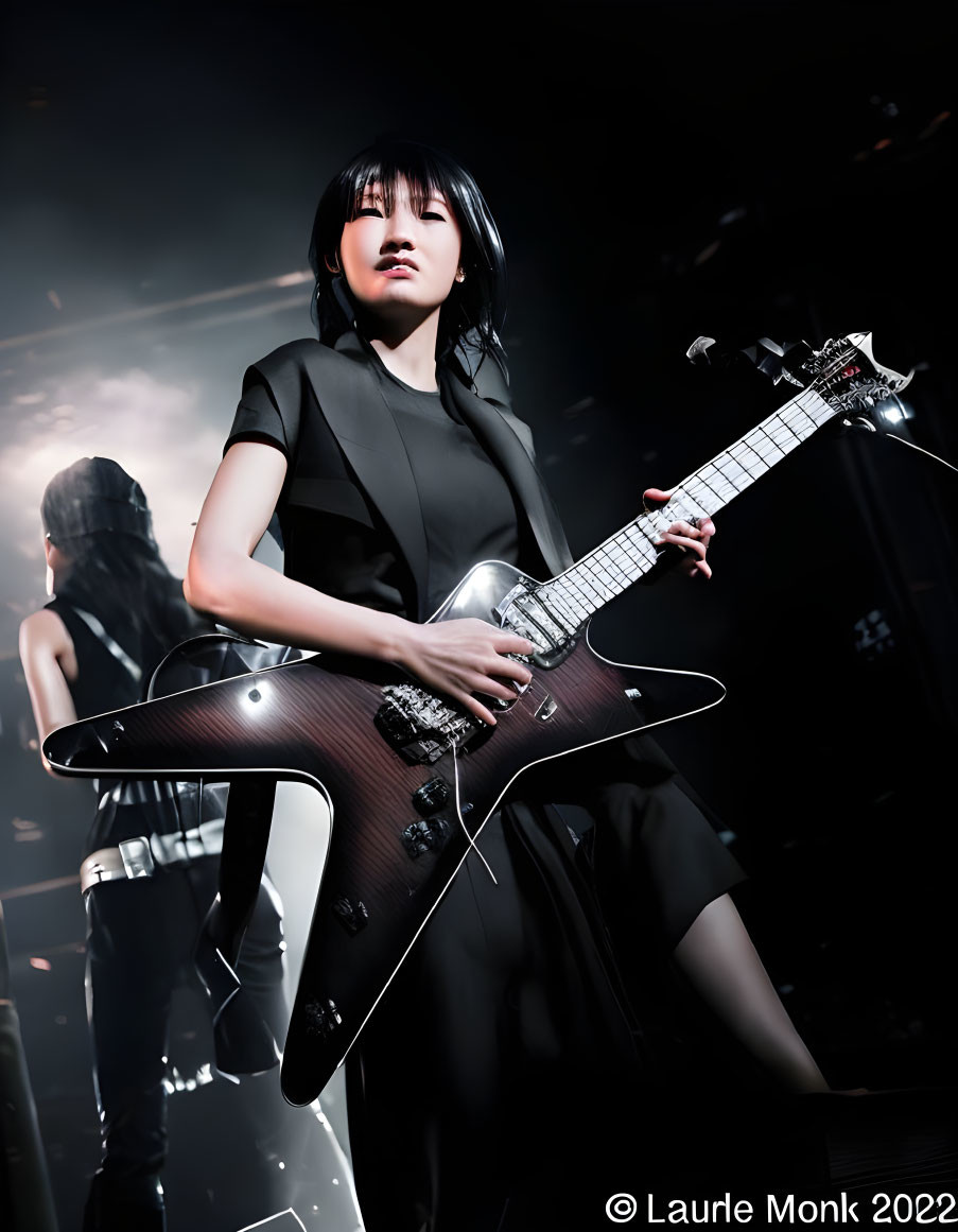 Woman Performs with Black Guitar on Stage in Spotlight