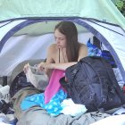 Woman sitting in tent surrounded by soft, ethereal glow