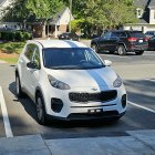 White Sports Car with Carbon Fiber Hood and Aerodynamic Body Kit parked on Sunny Street