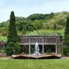 Manicured hedge garden with fountain and colorful flowers