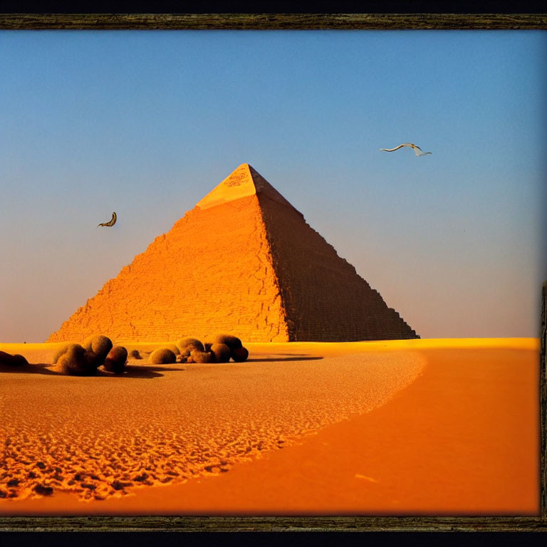 Pyramid silhouette at twilight with sandy foreground and birds in flight