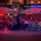 Vibrant blue buildings and colorful orbs illuminate mystical night street scene