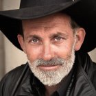 Distinguished man with grizzled beard and hat in portrait