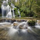 Tranquil waterfall in lush forest with vibrant foliage