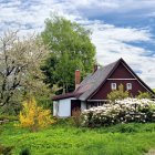 Rural landscape with thatched cottage, trees, and people in activities