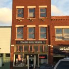 Three-story red brick building with balconies and bicycles at sunset