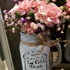 Blue floral pattern vase with pink blossoms on a table in serene still-life.