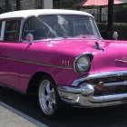 Bright Pink Classic Car and Humanoid Robot Figures Under Clear Sky